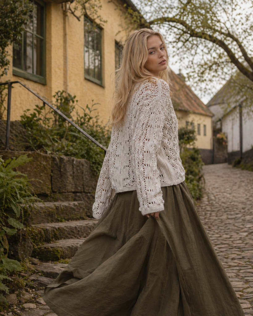 Outdoor movement photo of white knitted cardigan in village setting